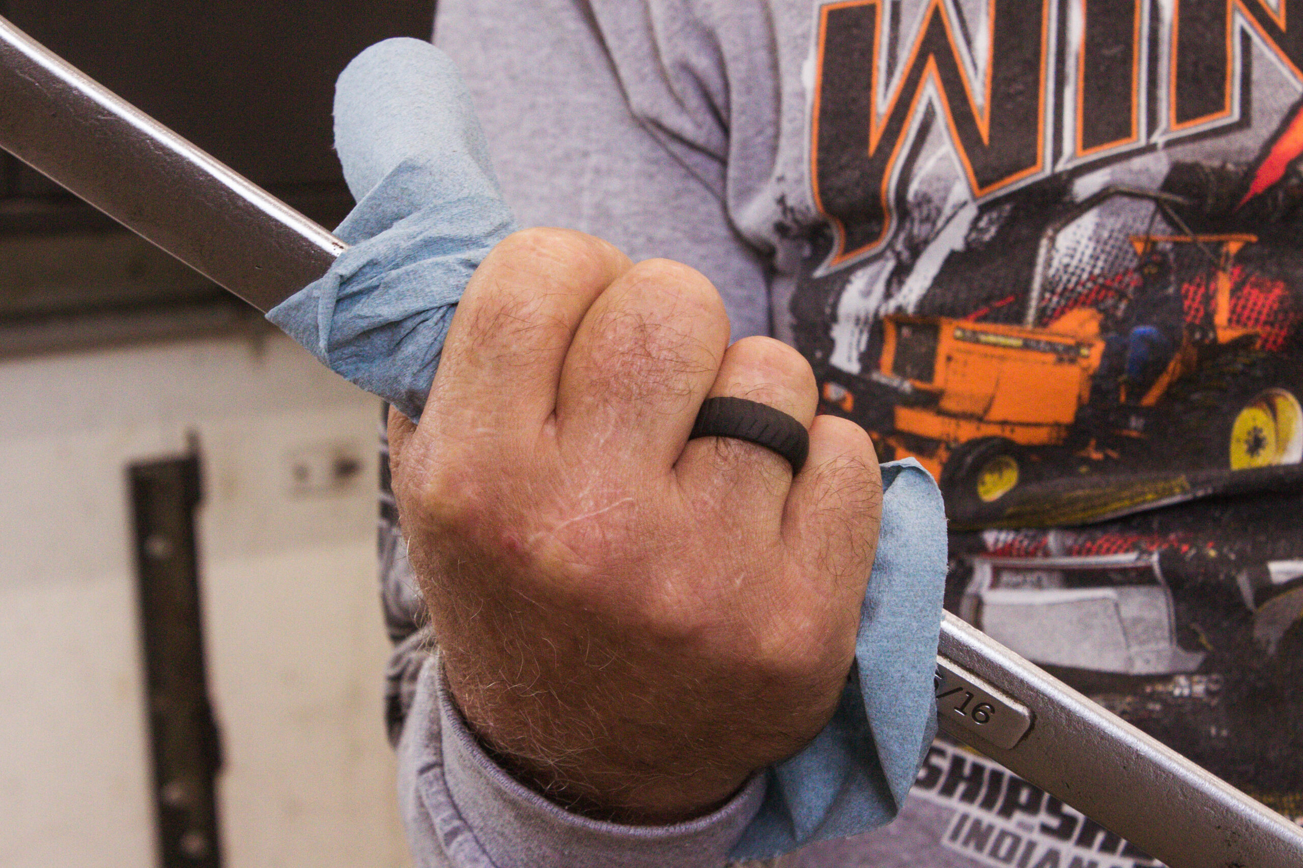 Man holding a wrench, wearing a silicone ring.